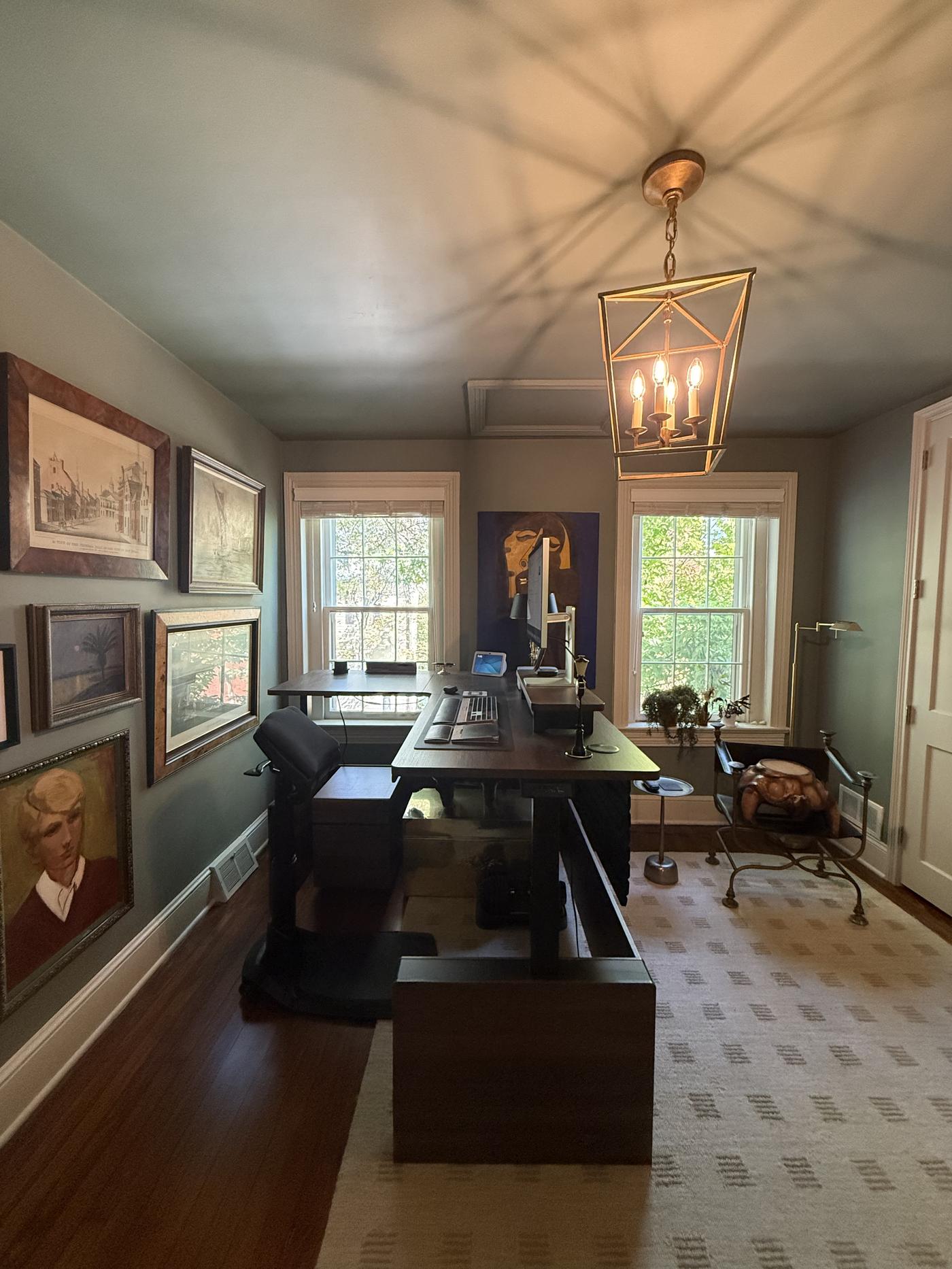 Study in slate blue with a gallery wall of paintings