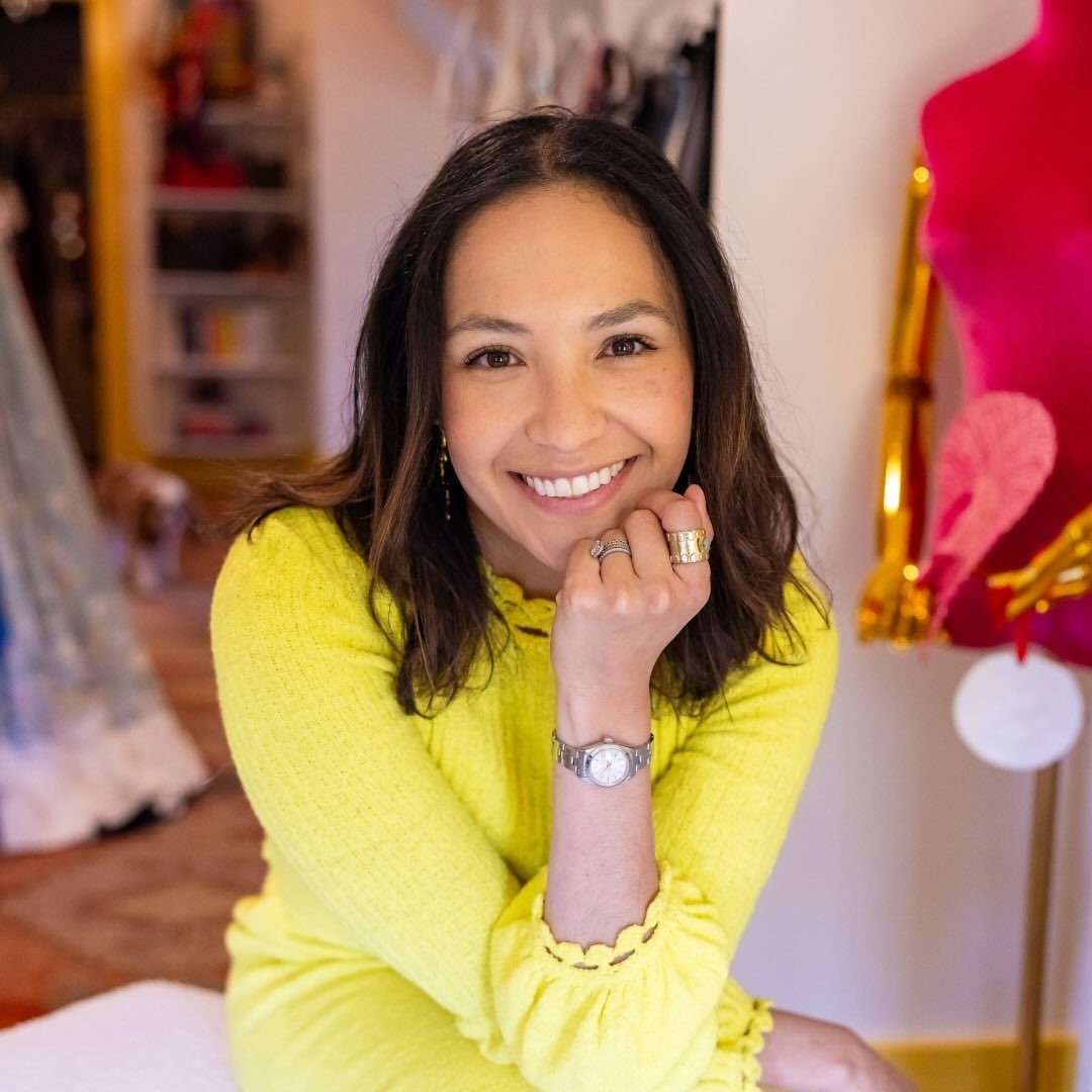 Natalia Lawrence in her studio, smiling in a yellow dress