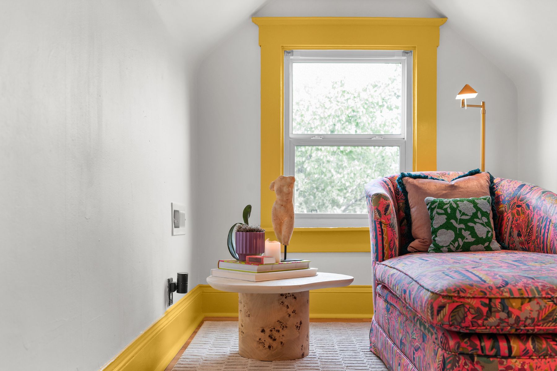 Attic reading nook with marigold trim and hot pink floral chaise