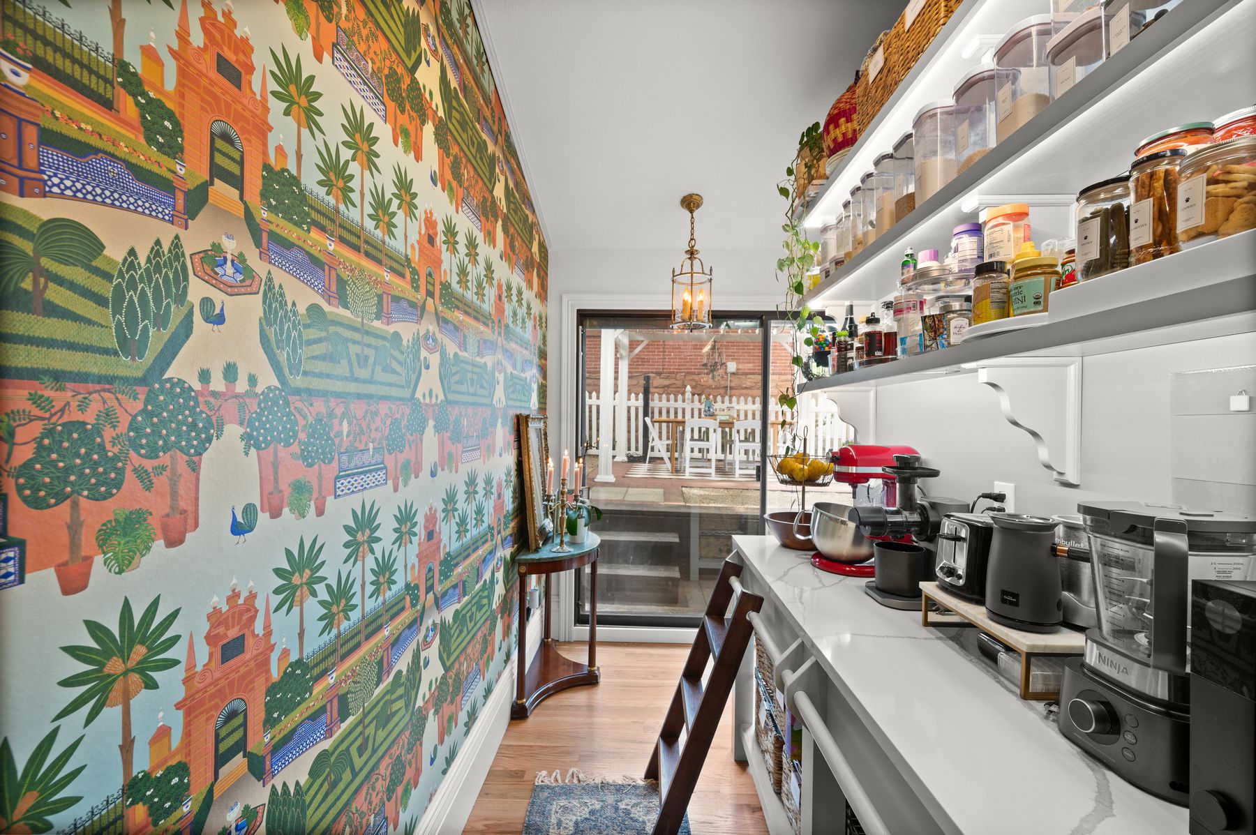 Butler pantry with Sevillian garden mural wallpaper and exposed brick
